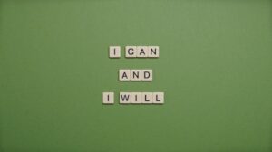 Inspirational message 'I Can and I Will' spelled with tile letters on a green background.
